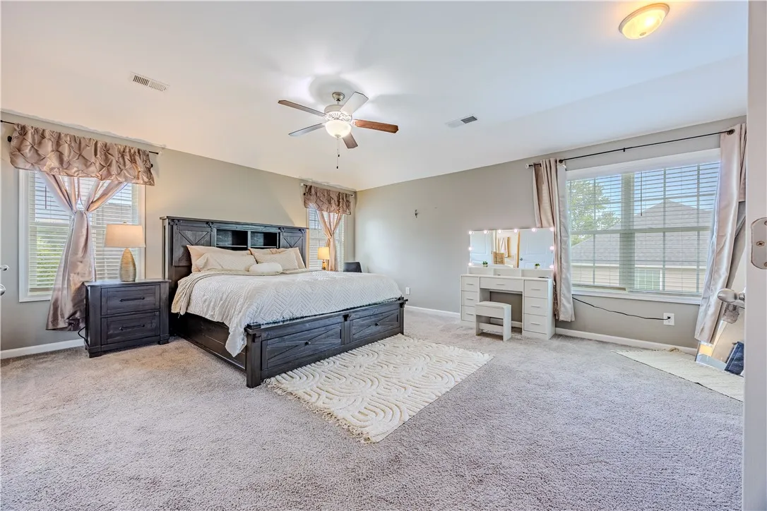 Relax in this tranquil bedroom, featuring plush carpeting and generous natural illumination.