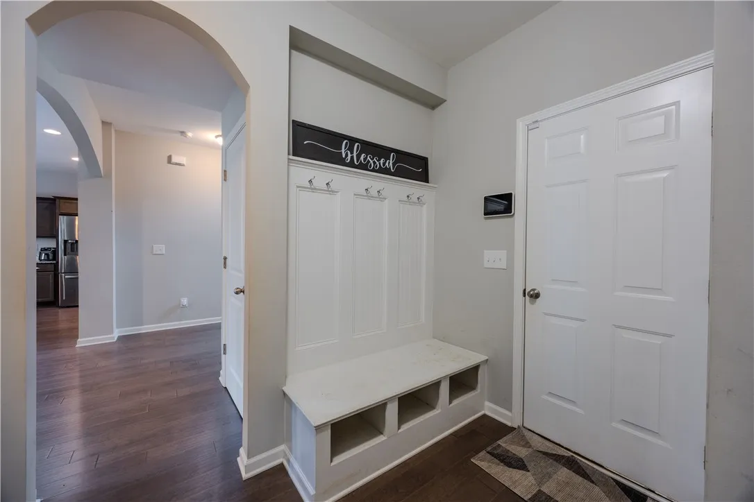 Enter through a welcoming foyer with rich hardwood flooring and convenient built-in storage.
