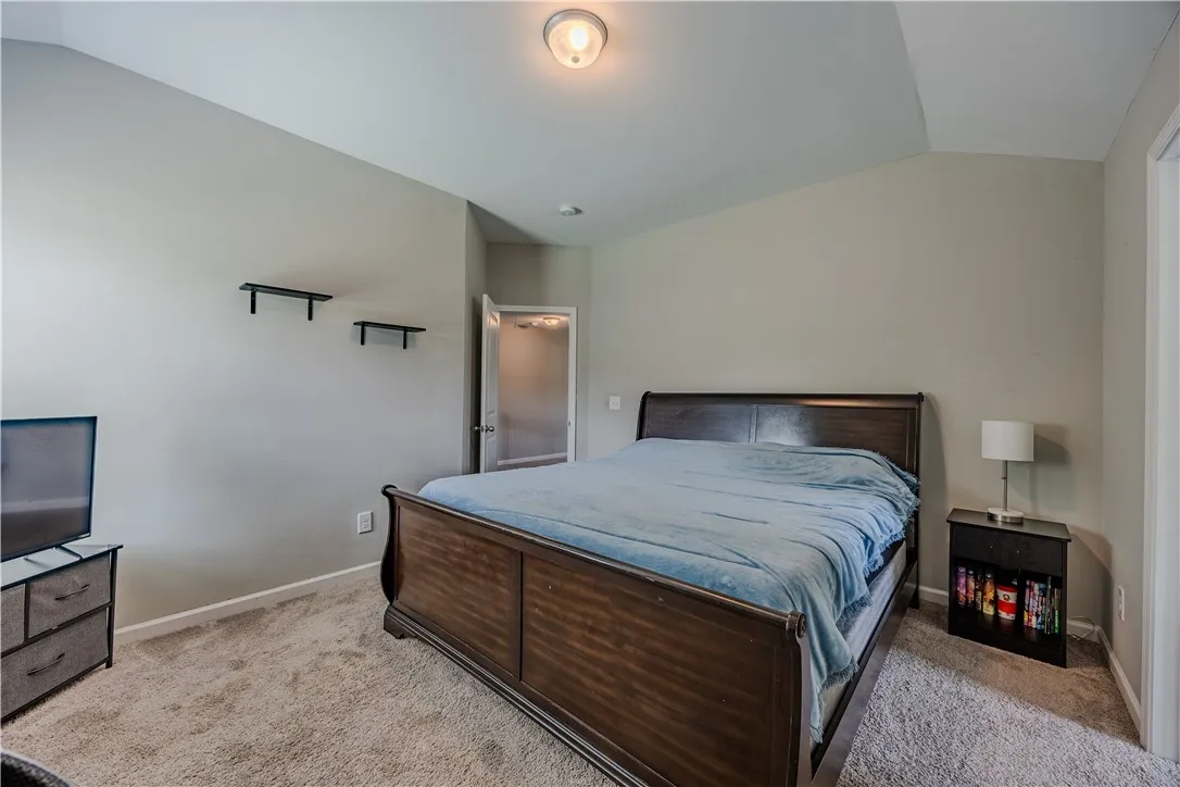 Sloping ceilings and soft carpet create a comfortable atmosphere in this well-lit bedroom.