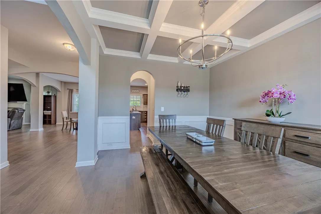 Formal gatherings find their perfect setting in this elegant dining space with detailed coffered ceilings.