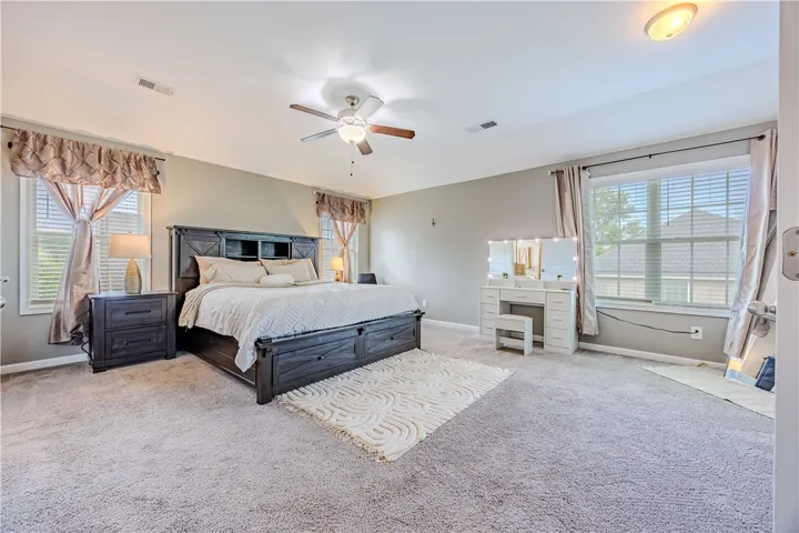 Relax in this tranquil bedroom, featuring plush carpeting and generous natural illumination.