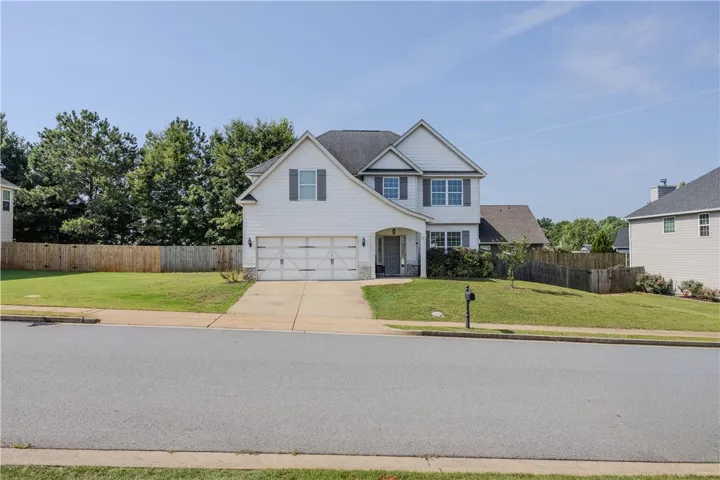 A classic two-story home with a neat lawn and a spacious driveway, beckoning a comfortable lifestyle.