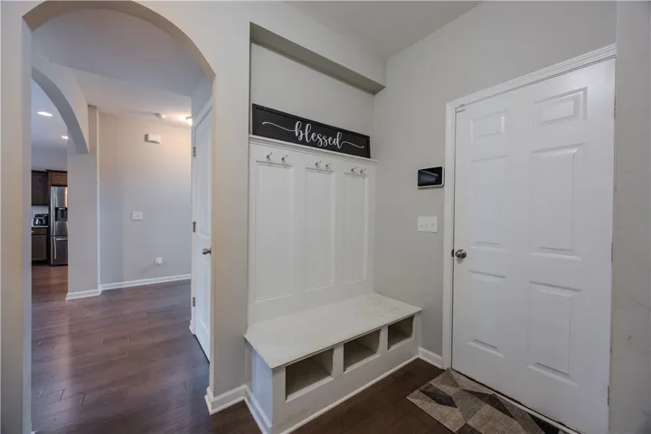 Enter through a welcoming foyer with rich hardwood flooring and convenient built-in storage.