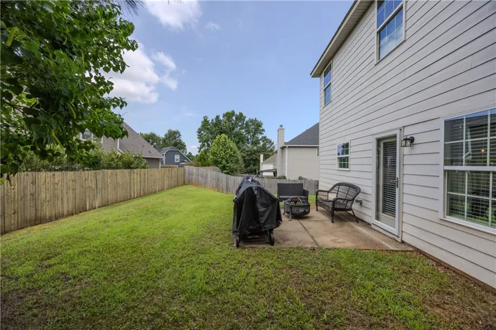 A fully fenced backyard with a concrete patio for outdoor enjoyment.