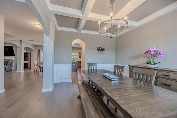 Formal gatherings find their perfect setting in this elegant dining space with detailed coffered ceilings.