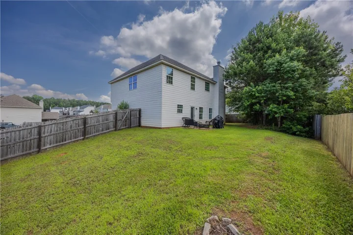 A generously sized yard, fully fenced for privacy, provides ample space for recreation and outdoor enjoyment.