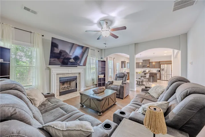 The inviting living room offers a cozy fireplace and direct sightlines into a well-appointed kitchen.