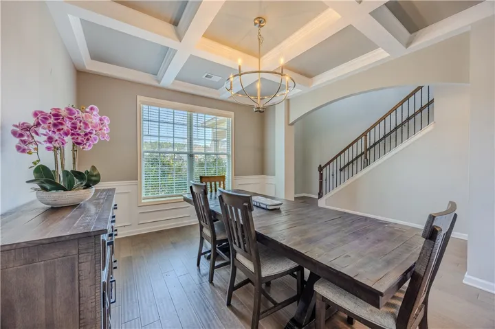 Ornate coffered ceilings and rich wood flooring define this elegant dining area.