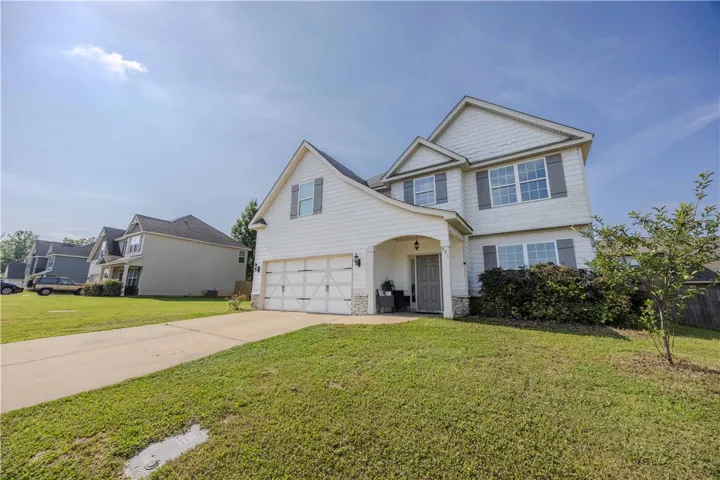 A classic two-story residence with a welcoming covered entry and an attached double garage.