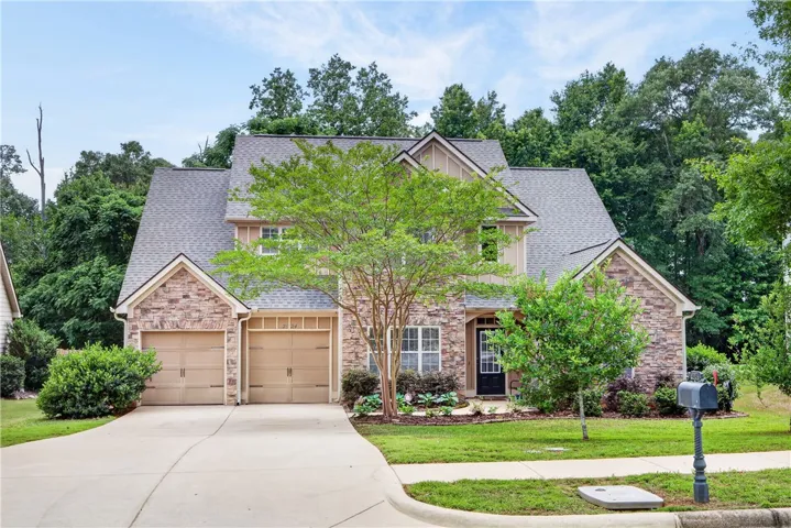 A welcoming stone and siding facade with a two-car garage invites you home.