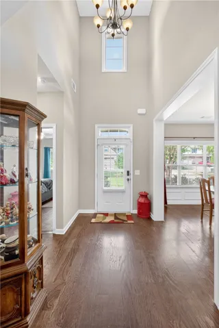 A graceful entrance boasts a soaring ceiling, lustrous hardwood floors, and a charming transom window above the main entry.