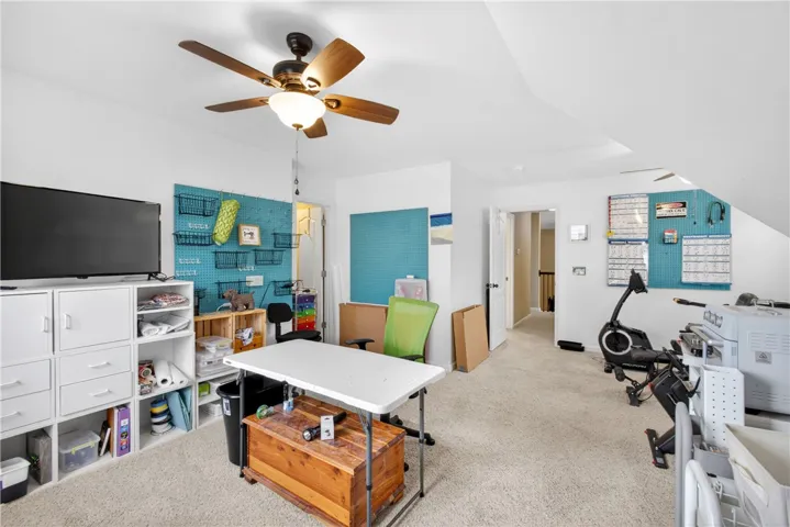 Another view of this versatile area can serve as a 5th bedroom or bonus space for a home office or exercise area, featuring practical carpet flooring.
