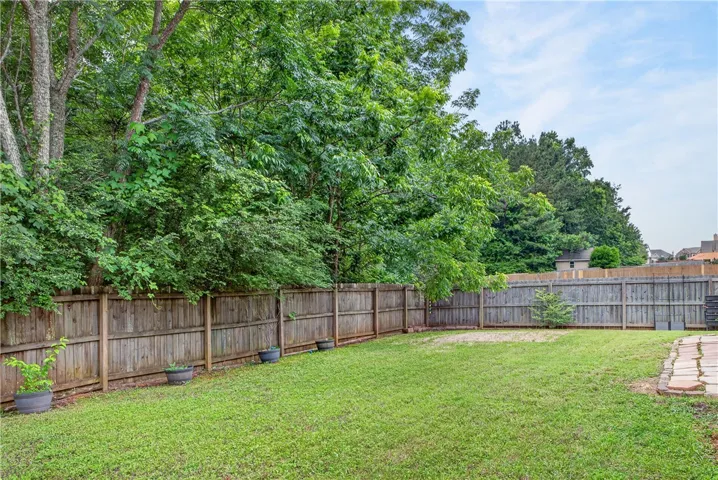 A well-maintained lawn provides a verdant canvas for outdoor living, bordered by privacy fencing and mature trees.