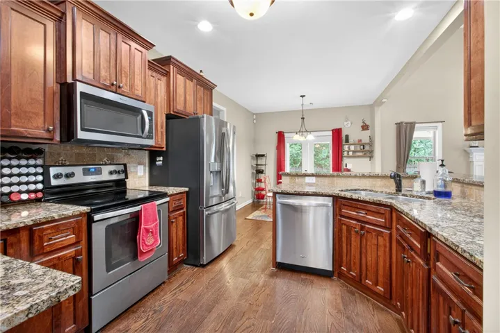A well-appointed kitchen features rich wood cabinetry, granite counters, and stainless steel appliances.