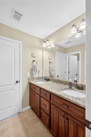 Granite counters and double vanity provide abundant space in this upstairs bathroom.