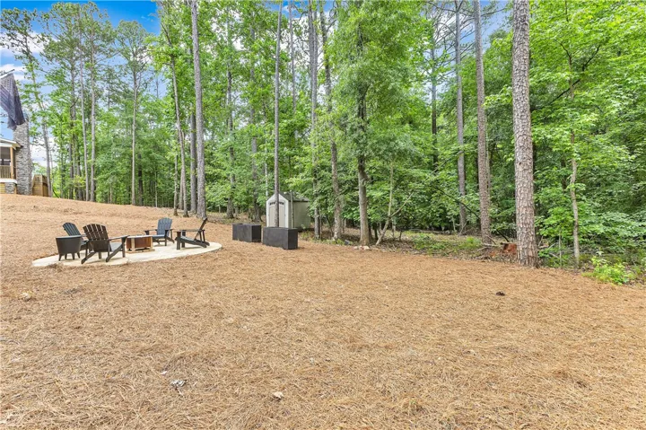 Relax in this peaceful woodland retreat, featuring a cozy outdoor fire pit surrounded by mature trees.