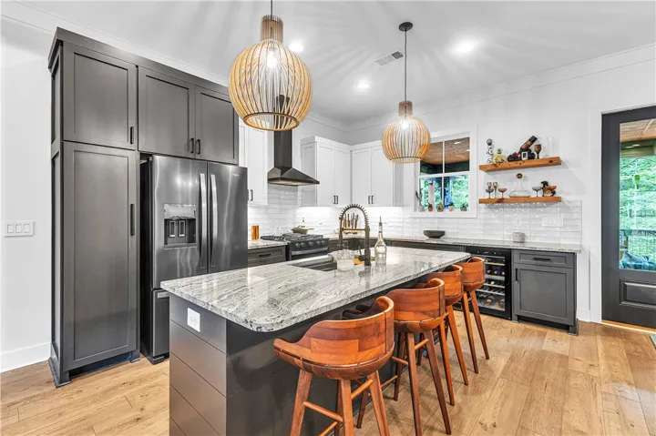 Gleaming wood floors and a granite island anchor this well-appointed kitchen.