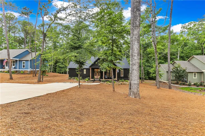 A spacious driveway welcomes you to this charming woodland property surrounded by natural landscaping.