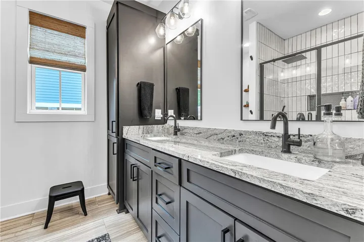 Granite counters and dual sinks define this stylish, functional bathroom space.