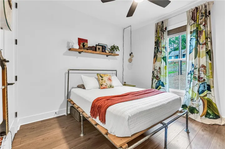 Hardwood floors and a ceiling fan create a comfortable atmosphere in this well-appointed bedroom.