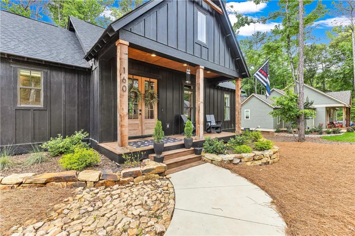 Board and batten siding frames a charming porch, offering a rustic-modern welcome.