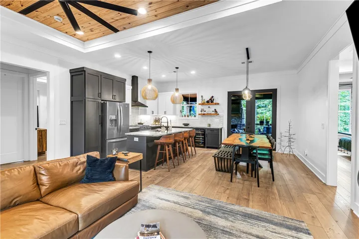 An open-concept living space features an impressive kitchen island with bar seating and a dining area.