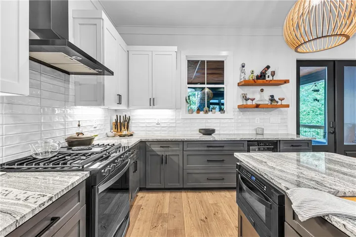 Modern kitchen with granite countertops and sleek, two-toned cabinetry.