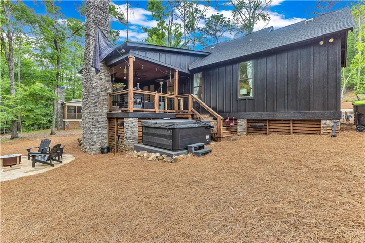 A private backyard oasis with a hot tub and fire pit area, perfect for unwinding amidst nature.