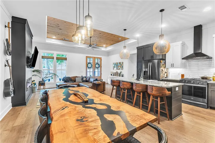 An open concept living area boasts a chef's kitchen, custom dining, and natural wood accents.
