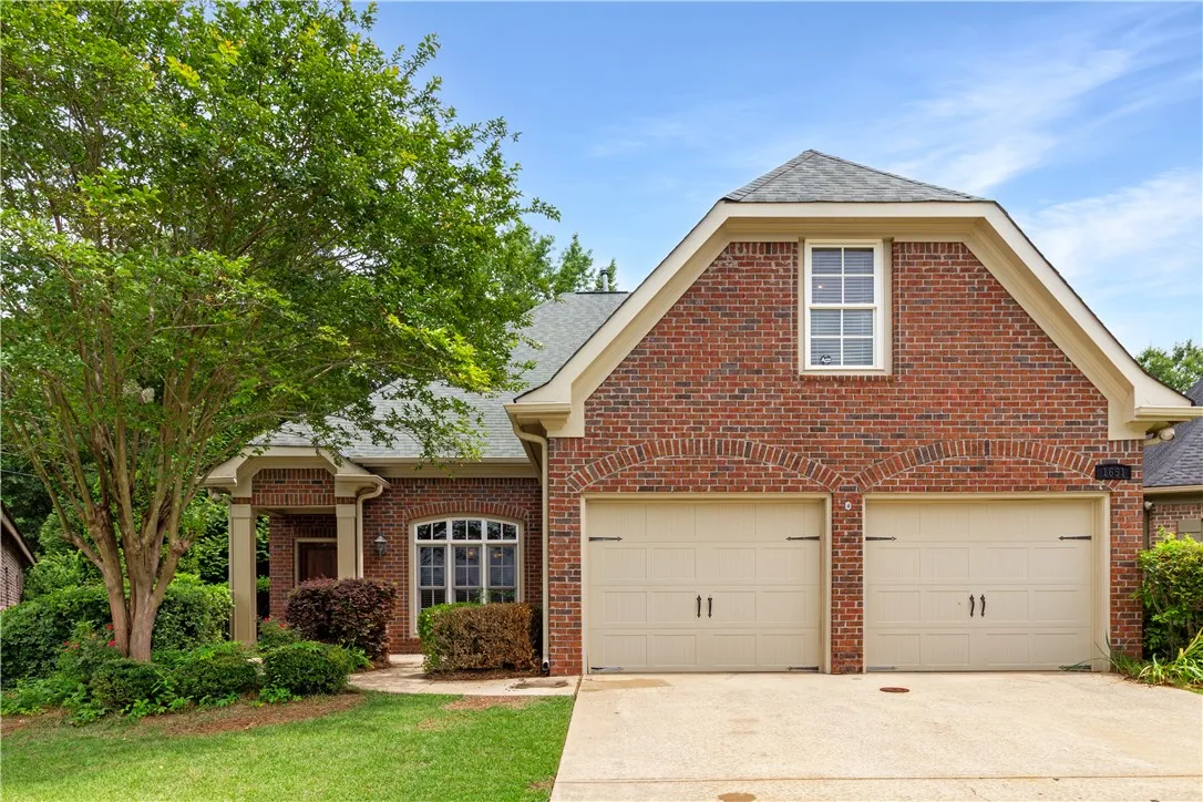 A classic brick exterior with inviting arched garage doors defines this charming residence.