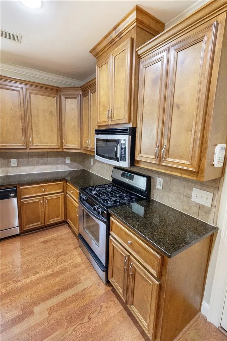 Prepare meals in a well-appointed kitchen featuring hardwood flooring and granite counters.