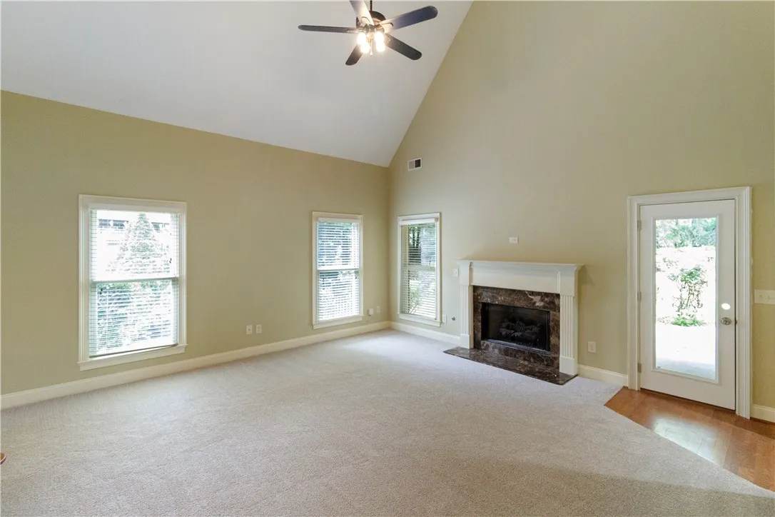 A spacious great room boasts soaring vaulted ceilings and a classic fireplace, perfect for gatherings.