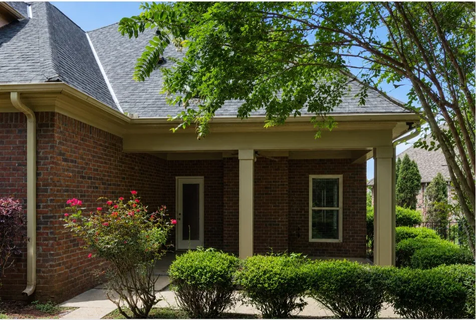 A classic brick exterior with a welcoming covered porch, ideal for shaded outdoor moments.