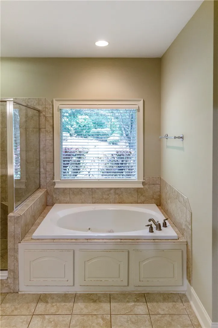 Luxurious soaking tub and tiled shower offer a private, spa-like bathroom experience.