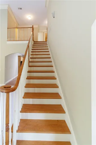 Elegant hardwood stairs with white risers lead to a bright upper landing and hallway.