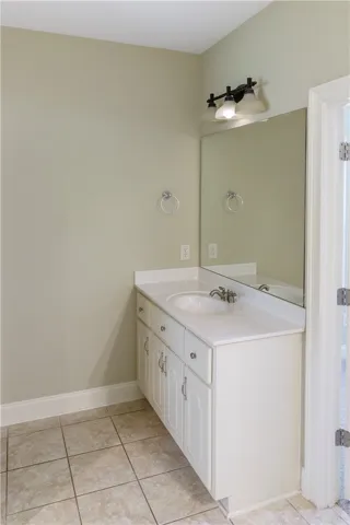 A well-appointed bathroom features a single vanity with ample counter space and convenient tile flooring.