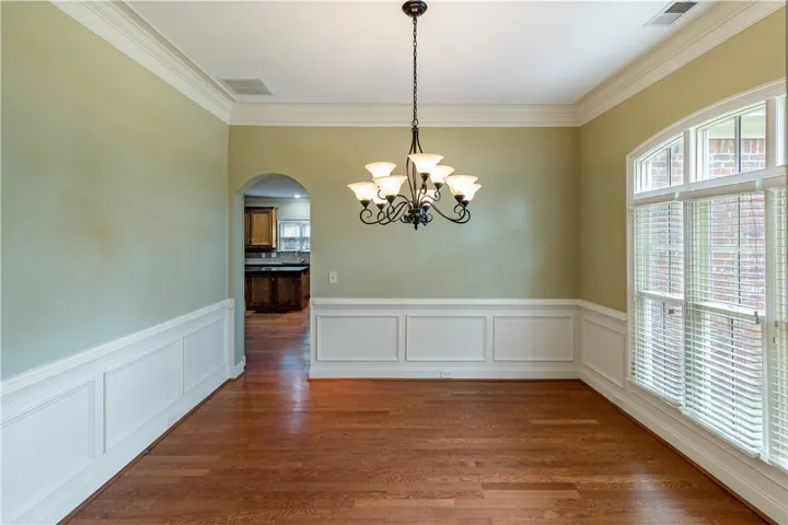 Elegant crown molding, chair rail, and hardwood floors define this classic dining space, perfect for memorable gatherings.