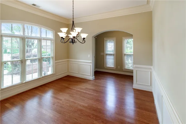 An inviting formal dining space featuring polished hardwood floors and intricate crown molding​​‌​​​​‌​​‌‌​‌‌​​​‌‌​‌​‌​‌​​​‌​​ details.