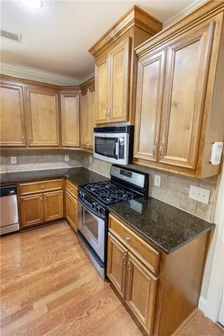 Prepare meals in a well-appointed kitchen featuring hardwood flooring and granite counters.