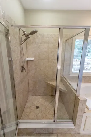 Indulge in a generously proportioned walk-in shower with integrated seating and classic tiled finishes.