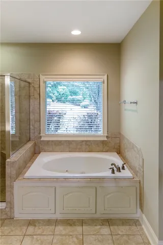 Luxurious soaking tub and tiled shower offer a private, spa-like bathroom experience.