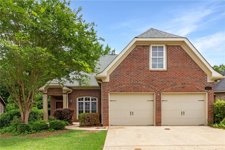 A classic brick exterior with inviting arched garage doors defines this charming residence.