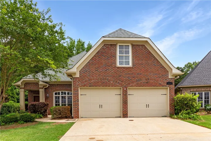 A classic brick exterior with a welcoming covered entrance and a practical two-car garage.