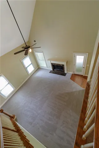 Grand living room with soaring ceilings and a cozy fireplace creates a comfortable ambiance.