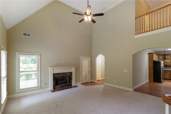 A spacious great room offers soaring ceilings, a central fireplace, and natural light.