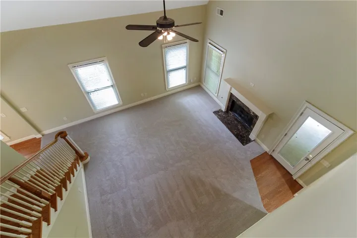 Experience lofty ceilings and a cozy fireplace with elegant hearth in this well-lit living area.