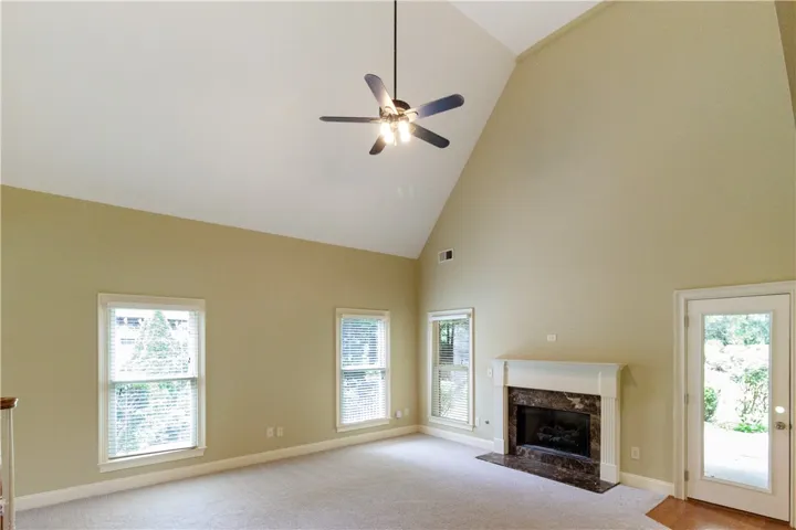 A spacious great room offers soaring vaulted ceilings and a classic fireplace.