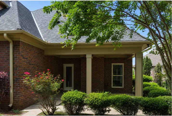 A classic brick exterior with a welcoming covered porch, ideal for shaded outdoor moments.