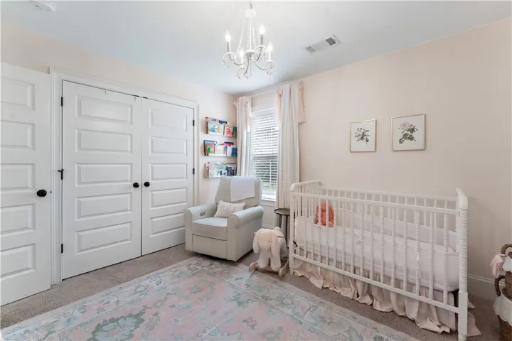 A well-lit bedroom with classic white doors and a charming crystal chandelier.