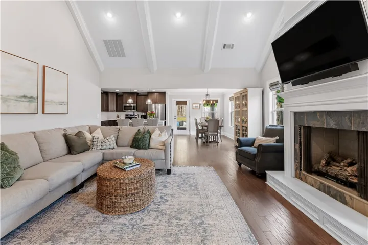 Step into a generously proportioned living space, offering an inviting fireplace and rich hardwood flooring.